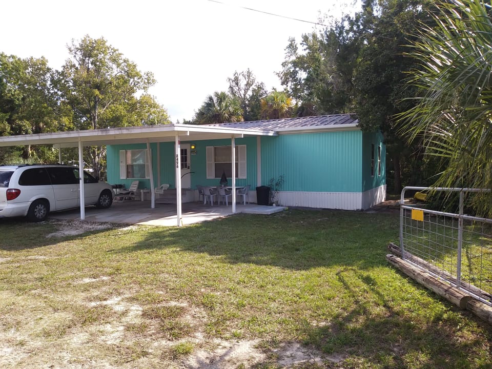 House at end of block, main entrance, carport, waterfront on two sides of lot. 