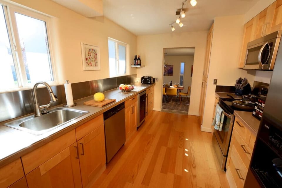 Kitchen hallway with stainless steel oven, microwave, and refrigerator