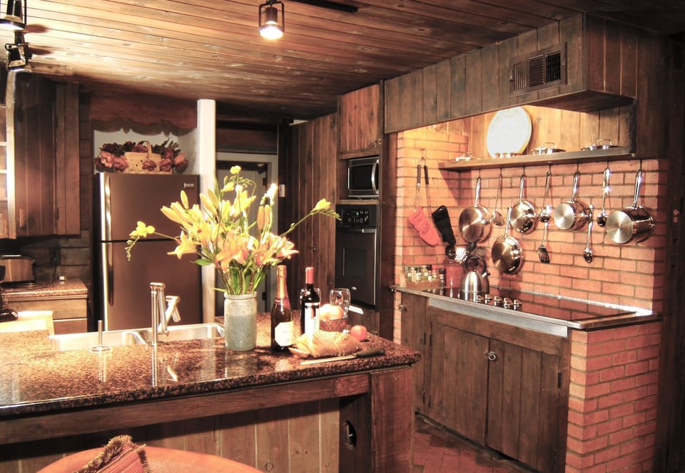 Ease of a 6-burner-cooktop-and the rustic elegance of brick & handmade cabinetry