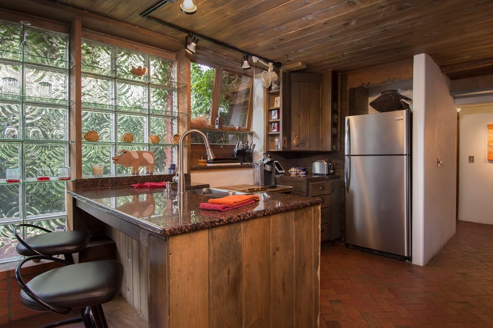 Block-Glass lit kitchen with granite counter top and leather bar stools.
