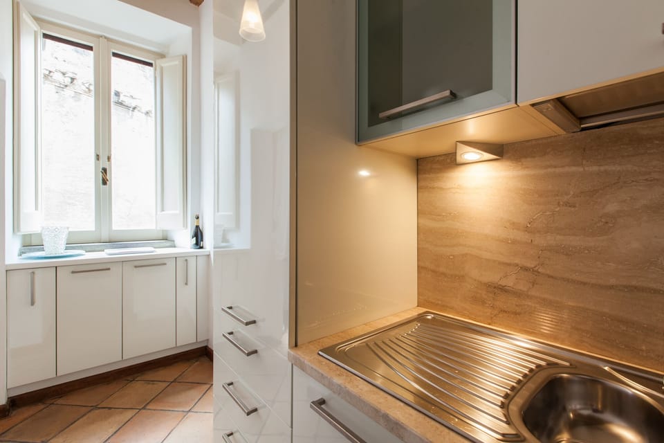 The cabinet under the window contains a washing machine