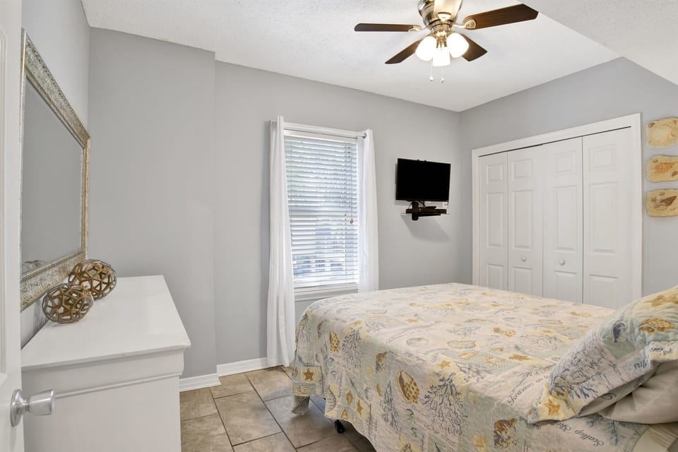 Bedroom 2 features a queen-sized bed, dresser, nightstand, TV and closet.