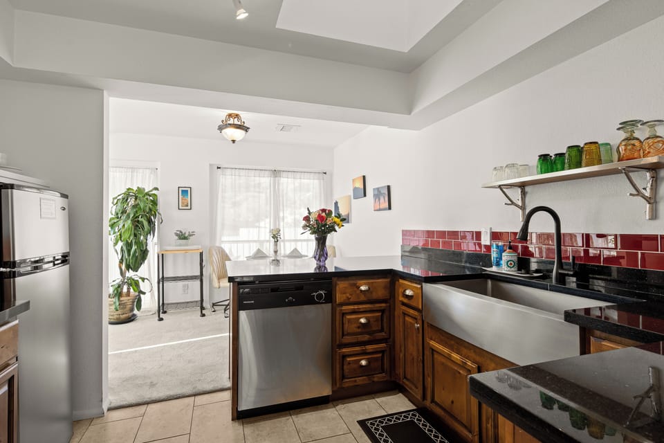 Kitchen with farmhouse sink, granite, dishwasher, dining nook.