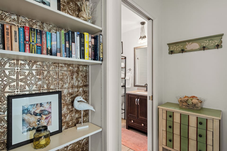 Bookshelf: vintage tin backsplash, curated reading material.