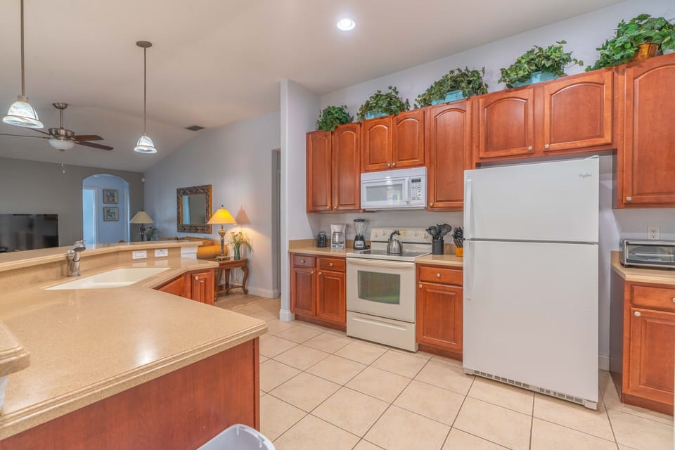 Kitchen, all appliances open with dining table and access to pool deck.