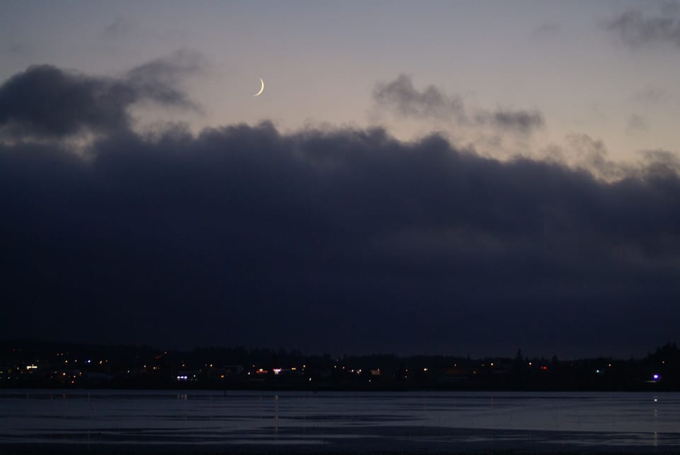 Sliver of a moon over a thick fog bank