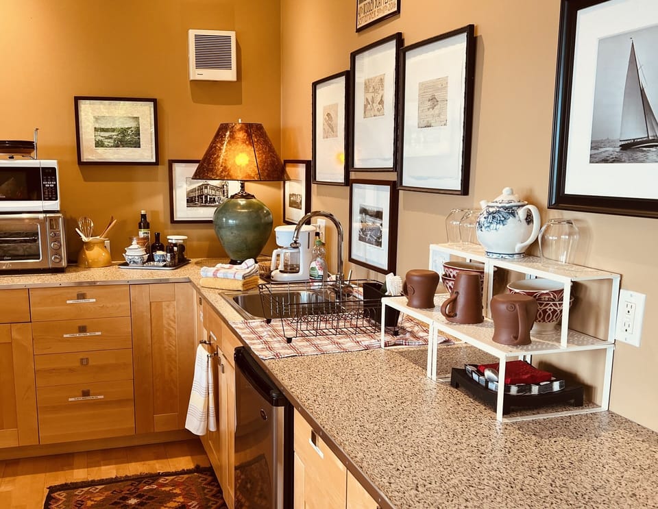 Kitchen area with sink and small fridge. 