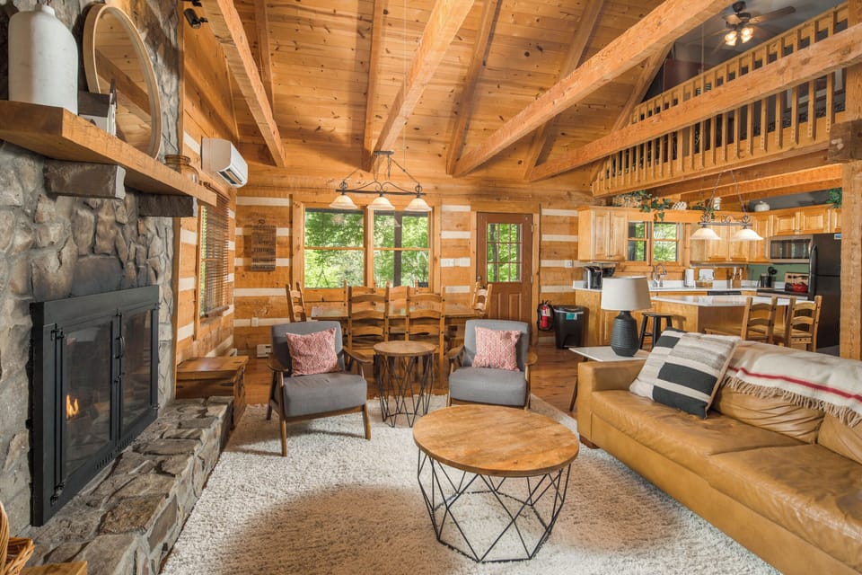 Floor-to-ceiling stone fireplace and vaulted timber ceilings create the perfect mountain retreat