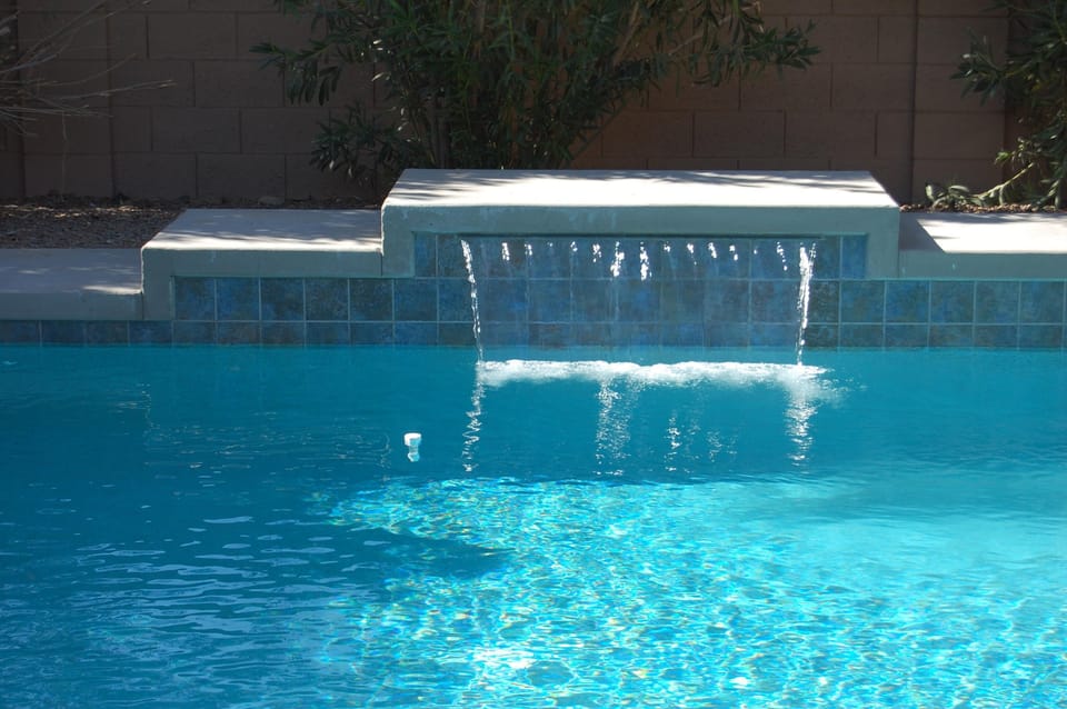 Pool with shear decent waterfall.