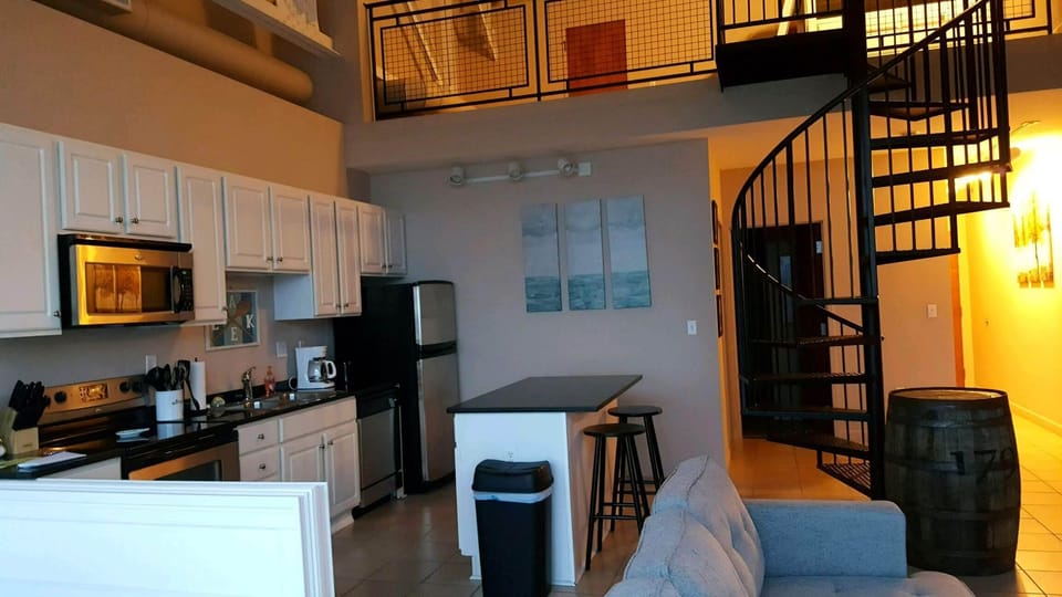 Full kitchen with electric stove, microwave, refrigerator, and cooking utensils.