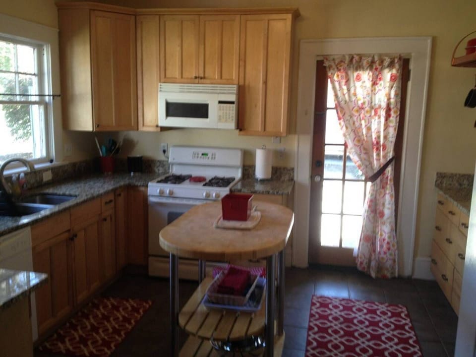 Granite countertops in Kitchen, Butcher block island, Gas Stove, Microwave, dishwasher, Copper, pot rack, and fully stocked kitchen.  "Bon Appetitte"