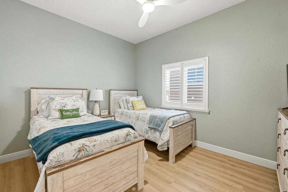 Perfect for kids or additional guests, this bright bedroom offers two comfortable twin beds, coastal accents, and plenty of space to relax.