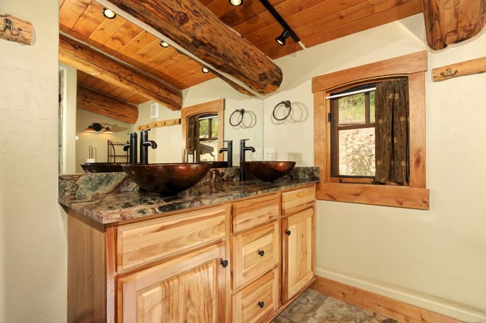 Grand master bathroom with double-sink vanity and glass shower.