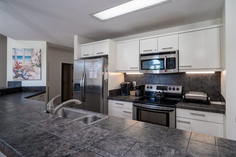 Even the most discerning chef will be impressed with this kitchen.  Stainless steel appliances, white cabinets,