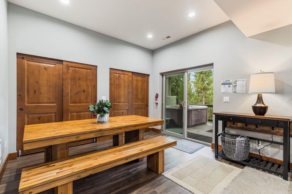 Casual dining area with two large picnic-style tables and access to a private outdoor patio.