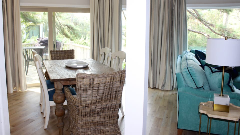 The dining area features a farm table with seating for six.