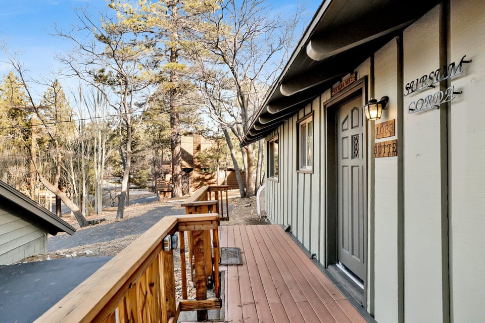 Welcoming cabin entry surrounded by towering pine trees, offering fresh mountain air and a peaceful forest setting—the perfect first impression for your Big Bear Lake getaway.