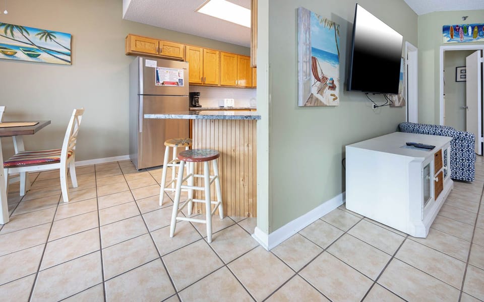 Kitchen area featuring wooden cabinetry, stainless appliances, breakfast bar, and a cozy dining space nearby