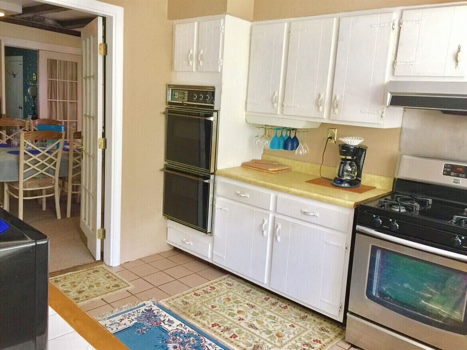 Older kitchen with coffee pot, microwave, dishes, pots and pans