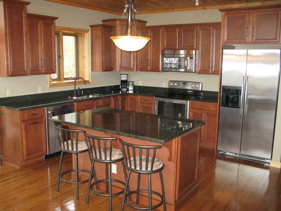 Full kitchen with granite countertops & stainless steel appliances.