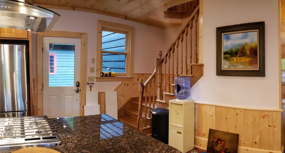Brand new hickory staircase leads from kitchen to renovated hall.