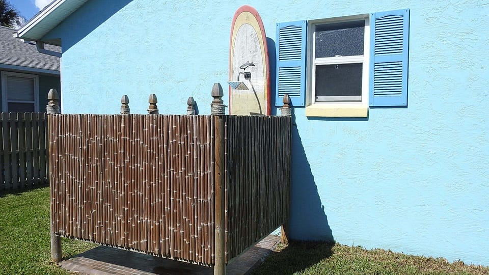 Outside enclosed rain shower on surfboard. 