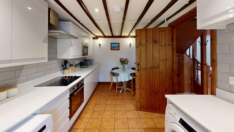 Traditional kitchen with beamed ceiling and terracotta floor tiles