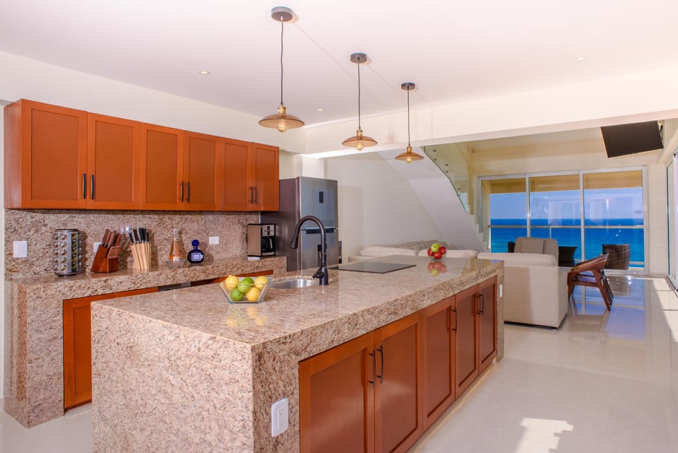 Spacious open-concept kitchen and living area framed by sweeping ocean views.