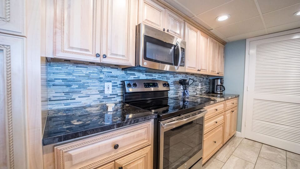 New appliances, backsplash, laundry room behind white door