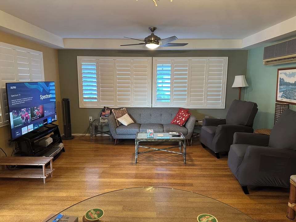 Living room with new 65 inch TV, new furniture and new window shutters!