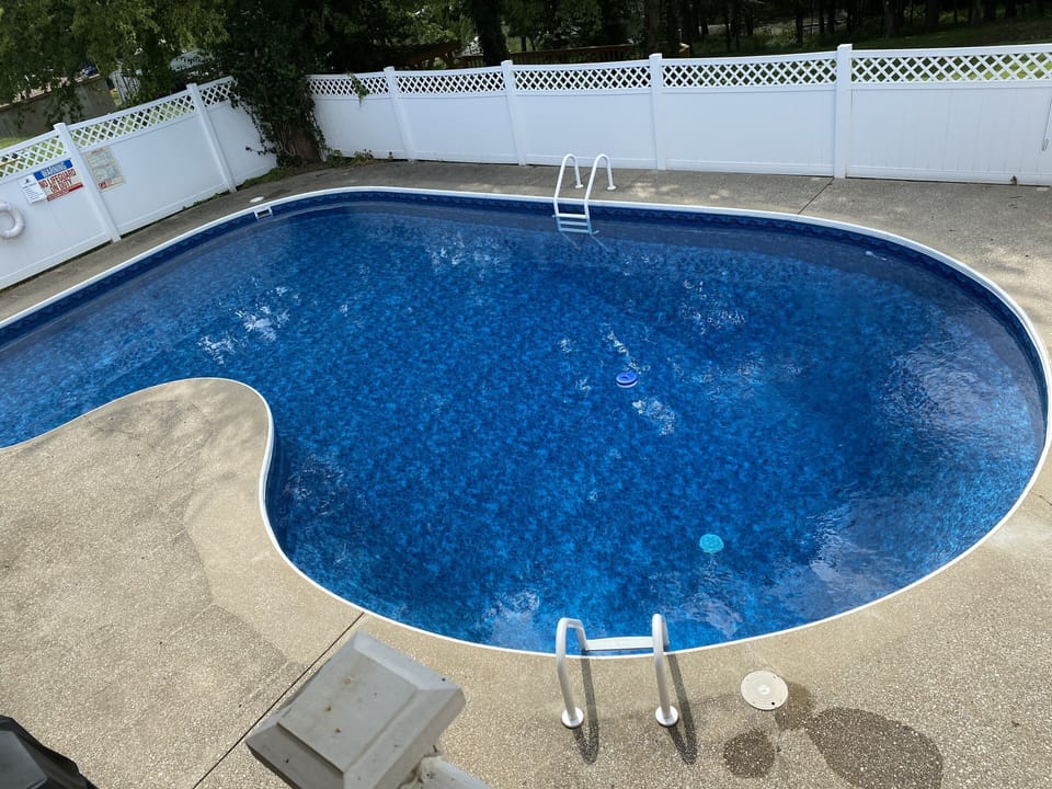 Private sparkling pool with propane barbecue overlooking lush land and the lake 