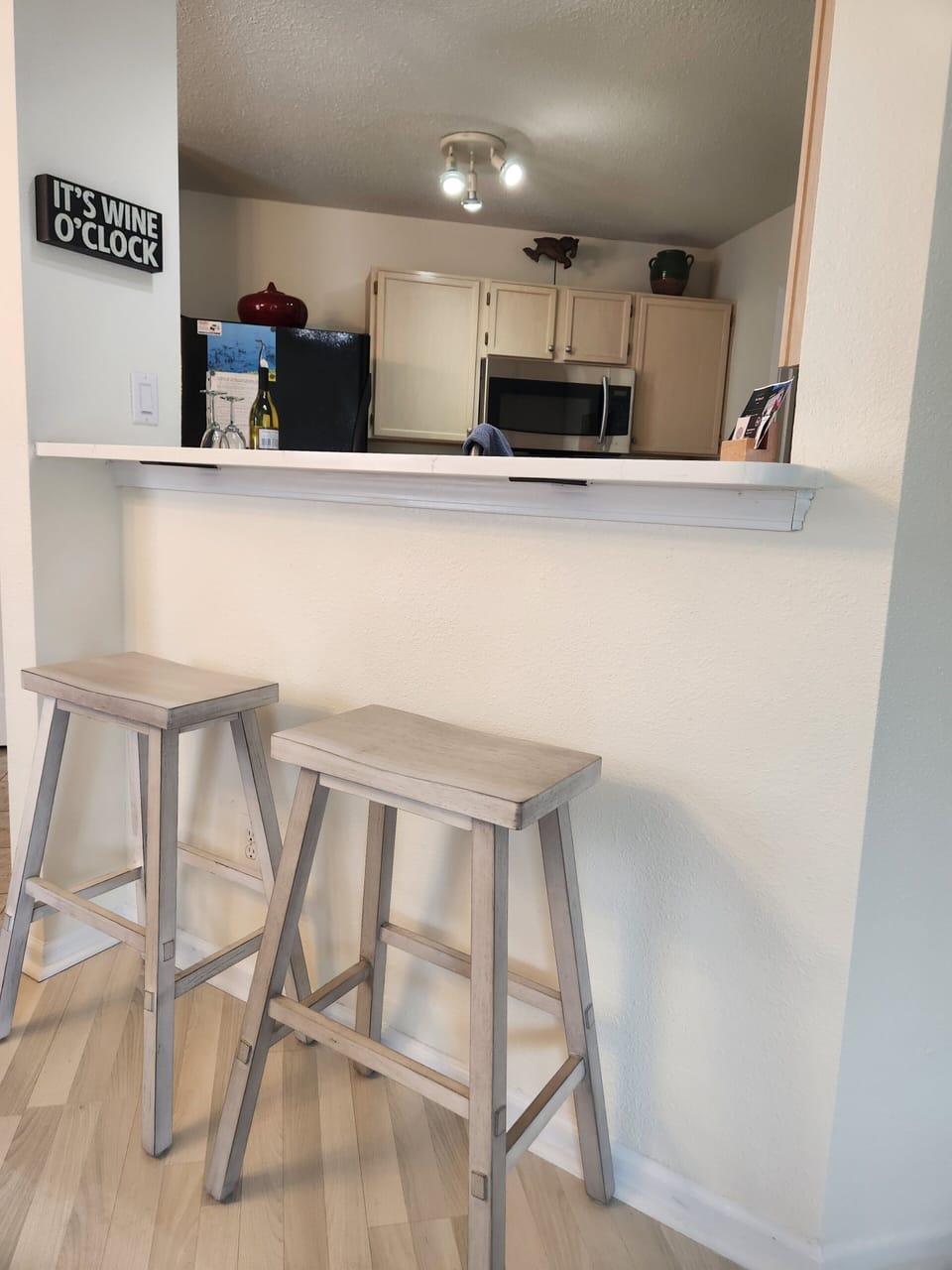 Extended kitchen countertop serves as a small serving area with bar stools.
