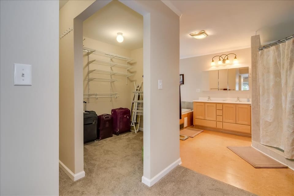 His and Hers walk in closet of the Master suite with open dressers for clothes.