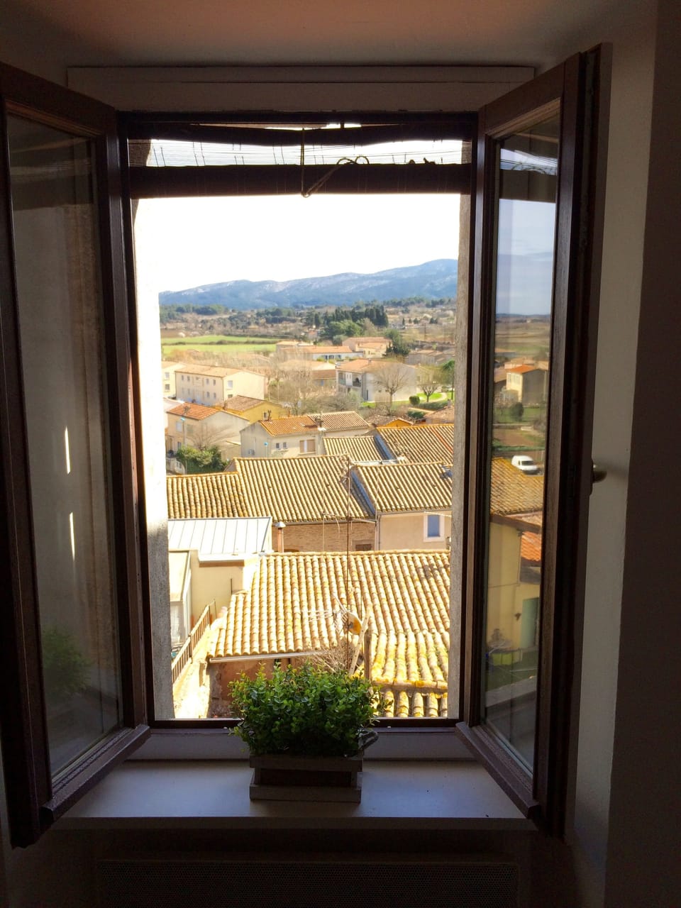 The view over terracotta tiled roofs down to the village below.