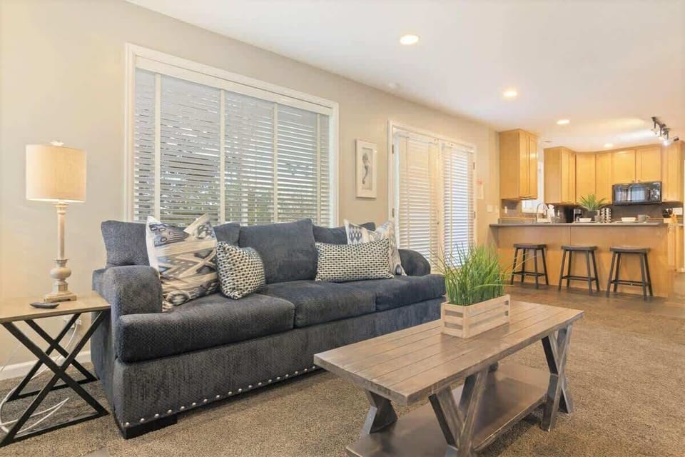 House 1 living room open to kitchen with door to hot tub