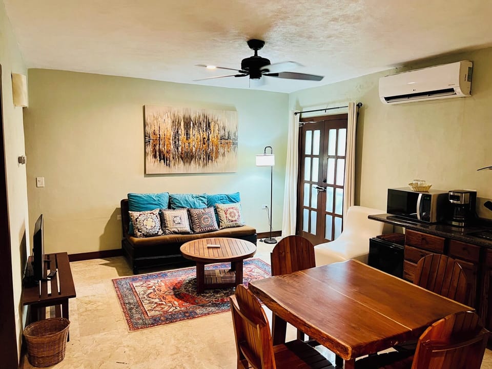 Full suite living area with a cozy sofa, dining table, and kitchenette