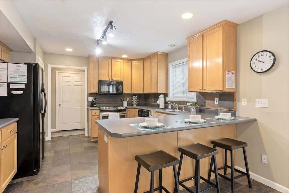 Beautiful full kitchen with bar seating for 3 and slate tile flo