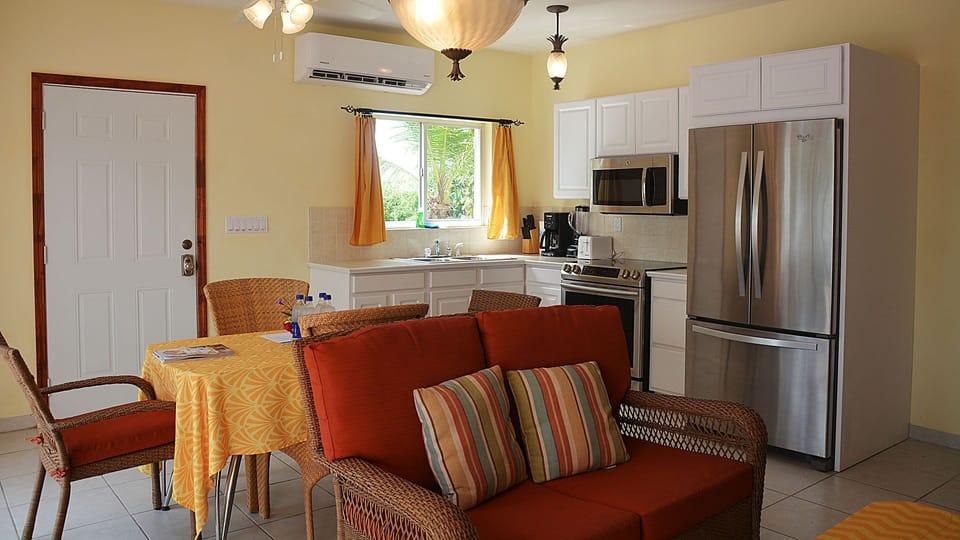 Kitchen, dining, and living area configured for four, with new appliances