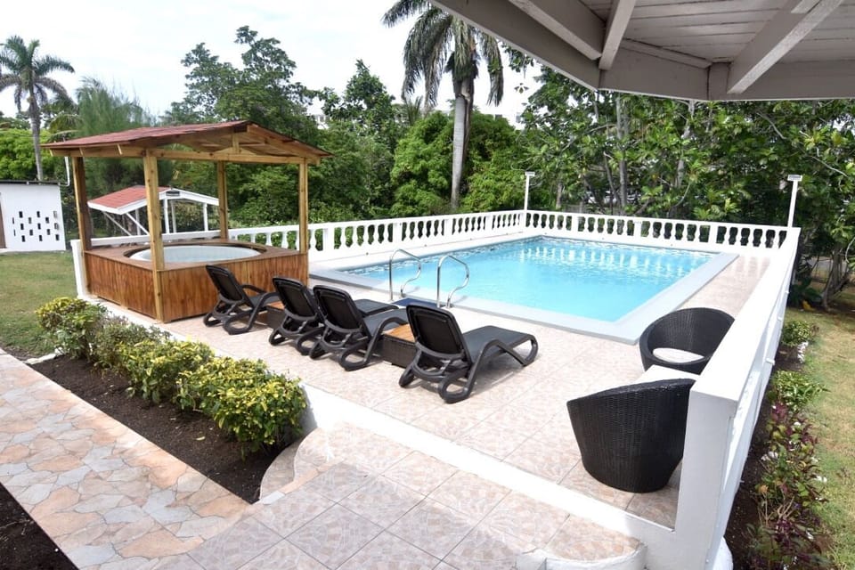 Swimming pool with spa to the left also BBQ pit in the background
