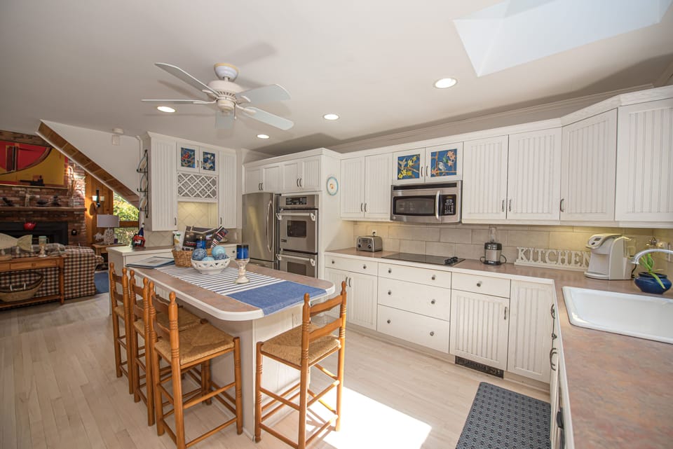 Kitchen island and wet bar with main gathering area to the left. Double oven