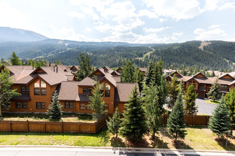Charming mountain community nestled among forested slopes with traditional alpine-style buildings and pristine natural surroundings.