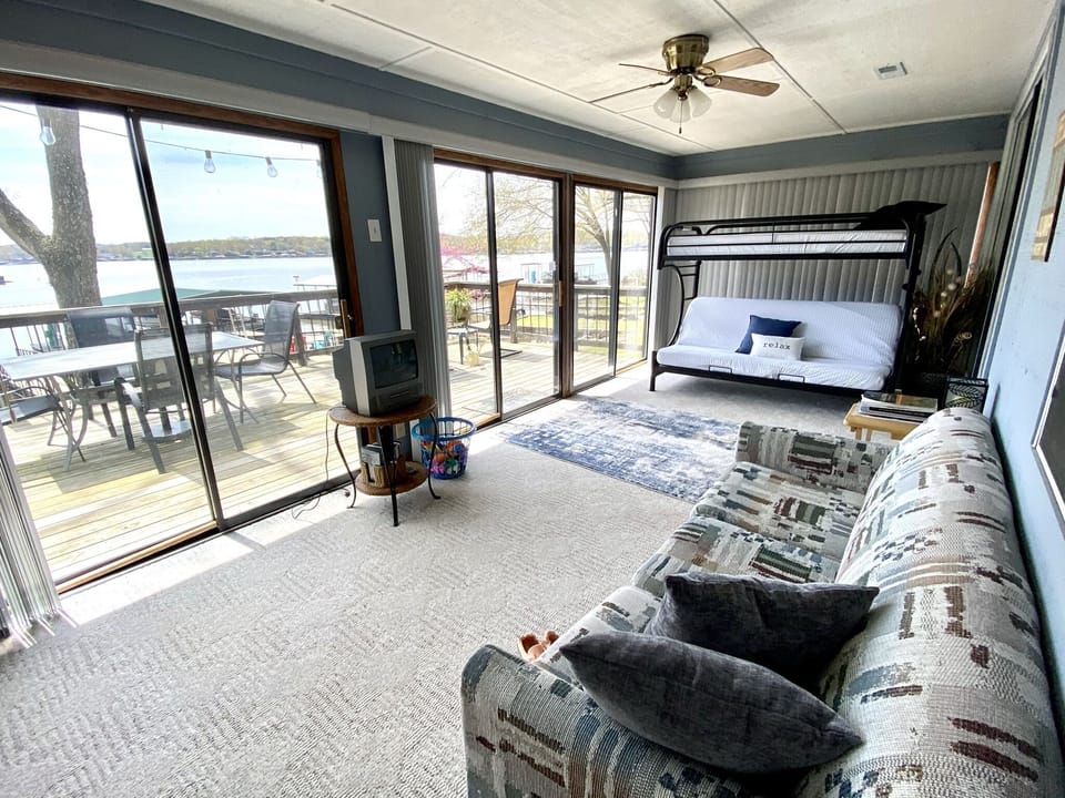 Sunroom with bunk beds and fold-out couch. Verticle blinds allow privacy.