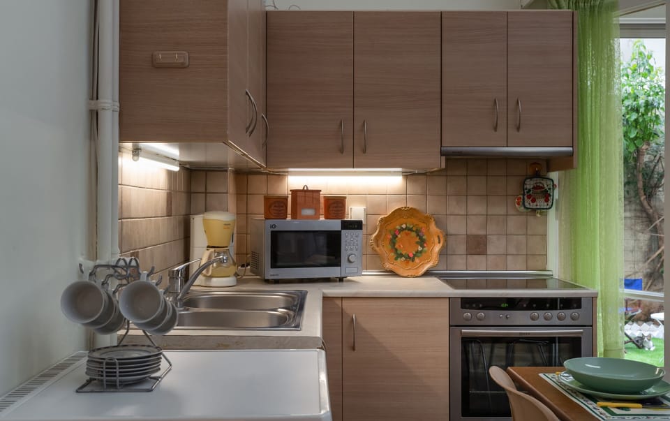 Fitted kitchen with an oven, glass stovetop, microwave, and coffee machine