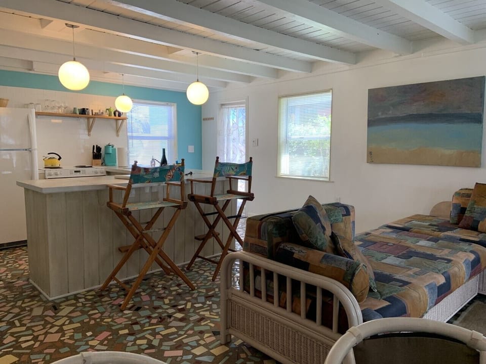 Partial view of the the living space and kitchen with wood beam ceiling.