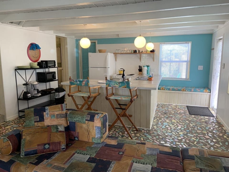 Partial view of the living space with kitchen in the background.