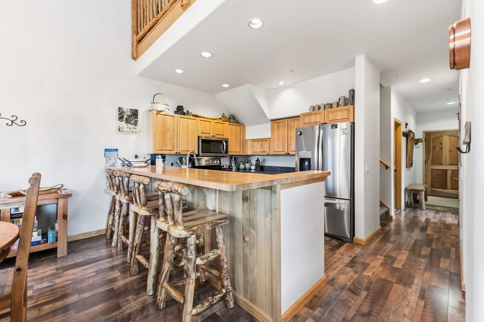 Your spacious kitchen features rustic wood bar seating, stainless steel appliances, and an open layout perfect for cooking and gathering.