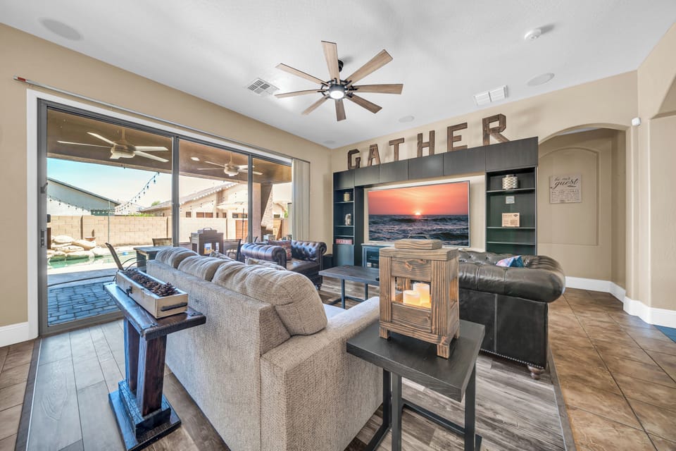 Living room with 86" TV and pool view, perfect for relaxing and gathering.

