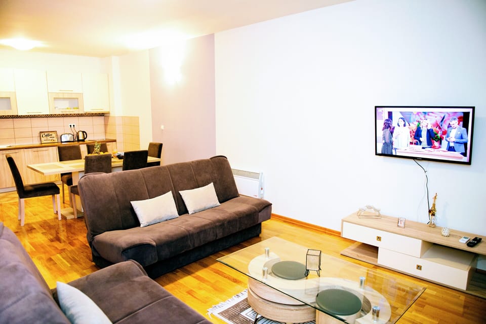 spacious living room with TV, air conditioning and balcony access