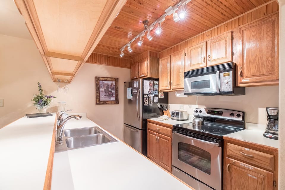 Kitchen with plenty of dishes, pot & pans. Condiments.