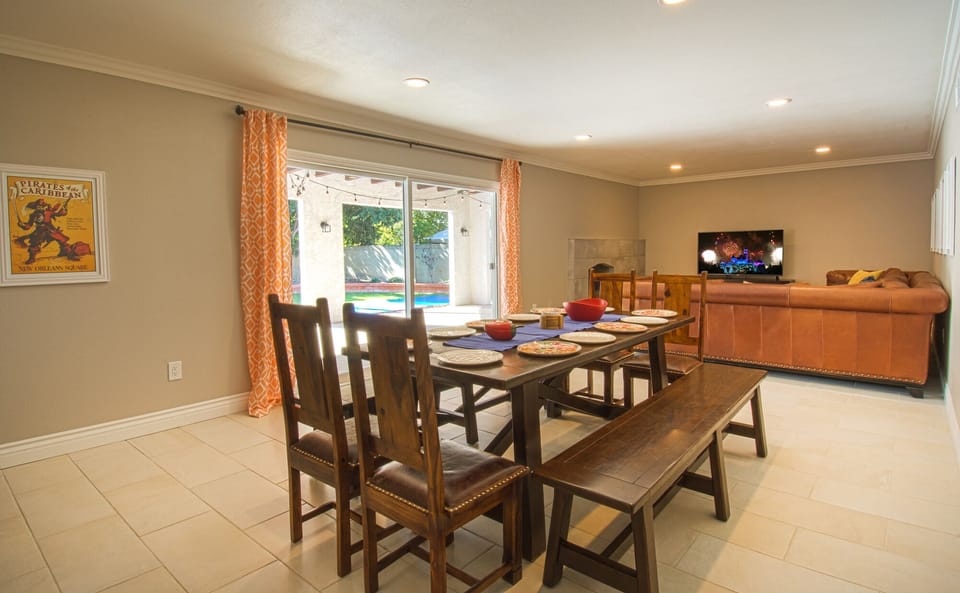 - Dining space with wooden table and sliding door to pool area   - Open layout combines indoor dining with outdoor pool access   - Spacious family dining area designed for group vacation meals